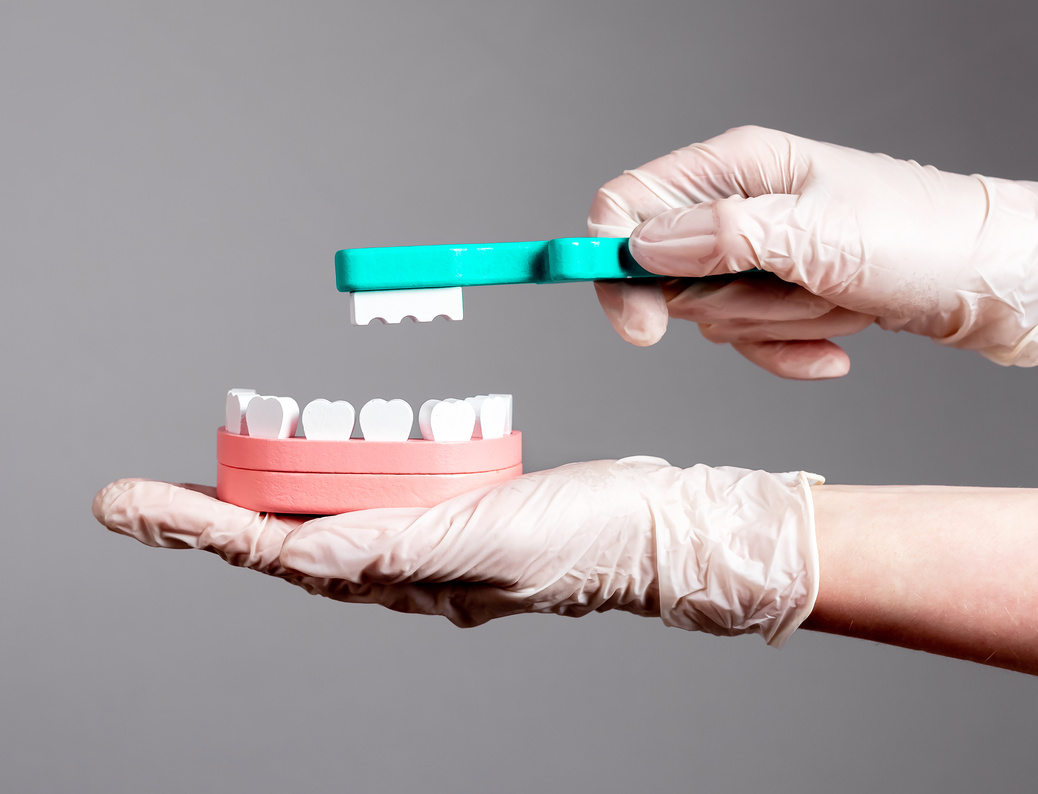 Brushing teeth on toy jaw model with kids toothbrush. Oral dental hygiene for children concept