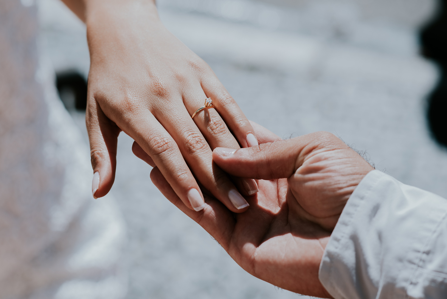 Anonymous newlywed couple showing wedding ring in daylight
